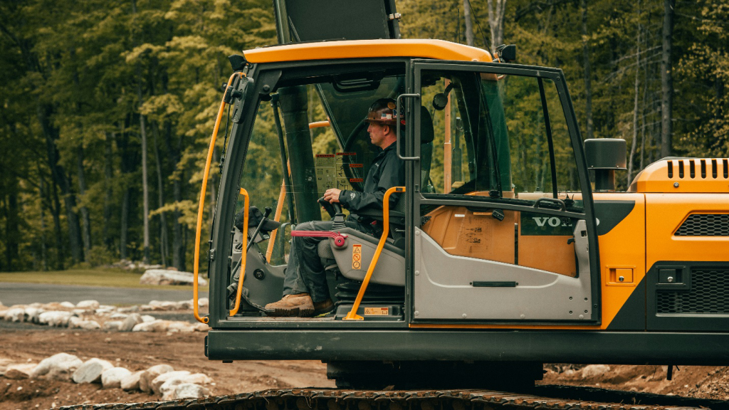 a person operating a yellow and black excavator 