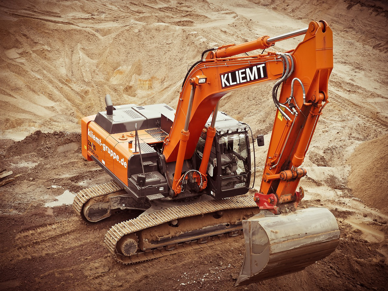 an orange excavator at a construction site